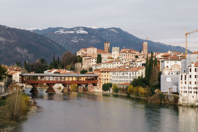 River by houses in town against sky