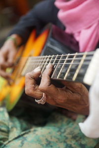 Close-up of man playing guitar