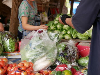 Midsection of buyer and seller at market stall