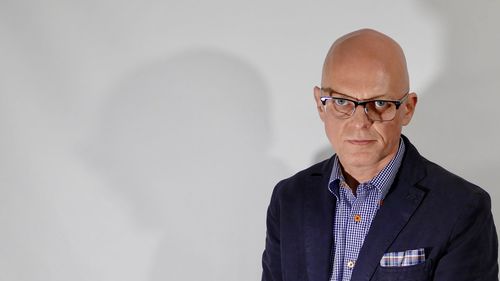 Portrait of man standing against wall