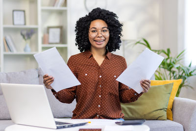 Portrait of young woman using laptop at home