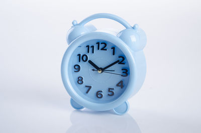 Close-up of blue alarm clock against gray background