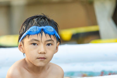 Portrait of shirtless boy wearing swimming goggles
