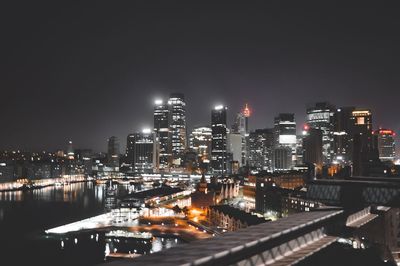 Illuminated buildings in city against sky at night