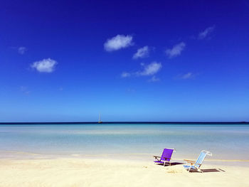 Sailboat on beach against blue sky