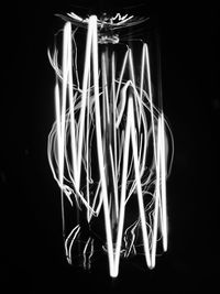 Close-up of illuminated lighting equipment against black background