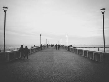 People amidst sea on pier