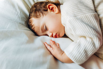 High angle view of baby sleeping on bed