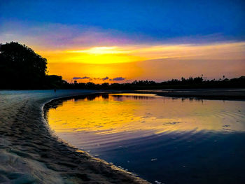Scenic view of lake against orange sky