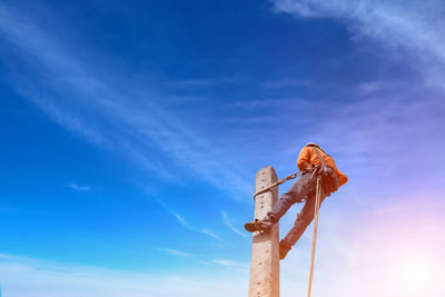 Low angle view of wooden post against sky