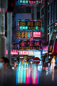 Illuminated text on street in city at night