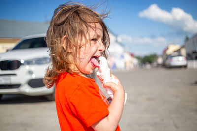 Young girl lickling vanilla ice cream. ice cream melts and flows on hand