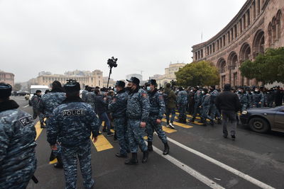 People on street in city against sky