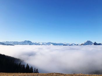 Scenic view of snowcapped mountains against clear blue sky