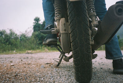 Low section of man riding bicycle on field