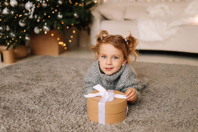 Portrait of young woman holding christmas tree