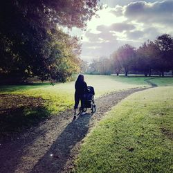 Rear view of man and woman walking on grass