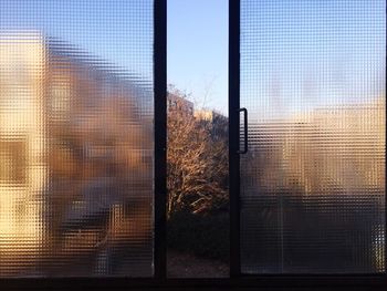 Close-up of silhouette glass window against sunset