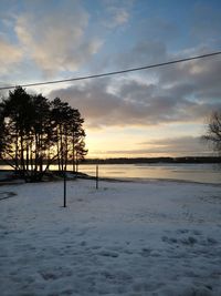 Scenic view of snow covered field against sky during sunset