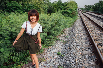 Young woman standing on railroad track