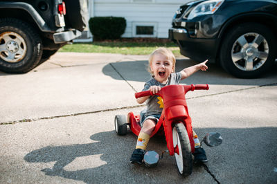 Young boy riding bike on driveway outside in summer