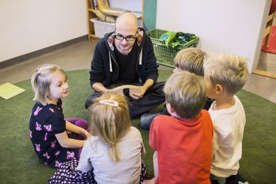 Teacher and students sitting on rug in kindergarten