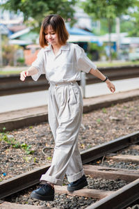 Full length of woman standing on railroad track