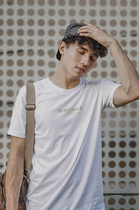 Young man standing against wall