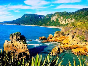 Scenic view of sea and mountains against blue sky