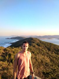 Young man standing on land against sky