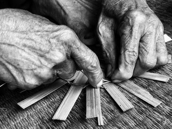 Cropped image of person weaving wicker