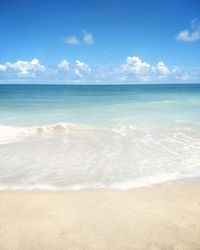 Scenic view of beach against blue sky