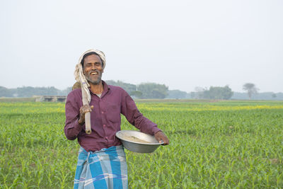 Portrait of smiling man standing in field