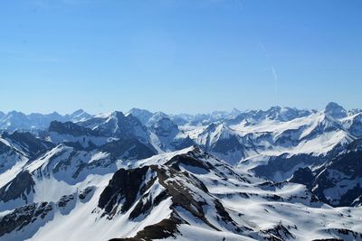 Scenic view of snowcapped mountains against clear blue sky