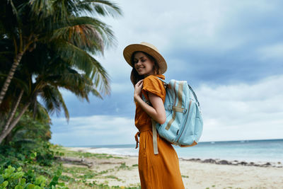 Full length of man standing at beach against sky