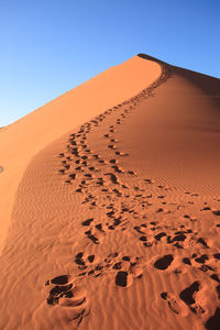 Sand dune in desert against clear sky