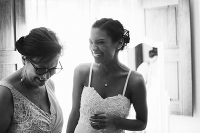 Cheerful bride looking at mother