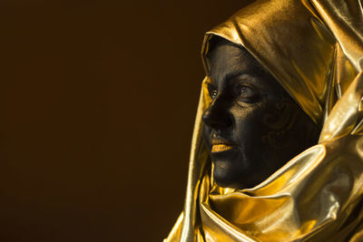 Portrait of a woman with black and gold make up, close up