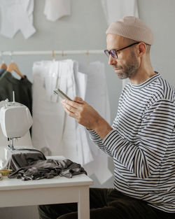 Side view of man using mobile phone at office