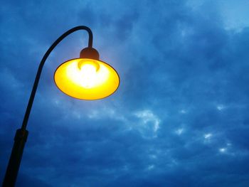 Low angle view of illuminated street light against sky