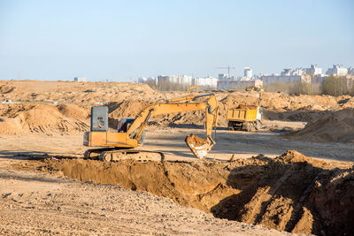 Large excavator working at construction site. backhoe during earthworks on sand open-pit.