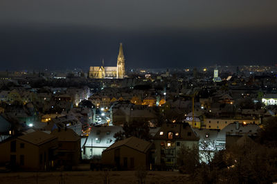 Illuminated cityscape against sky at night