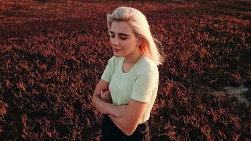 Woman with eyes closed standing on field