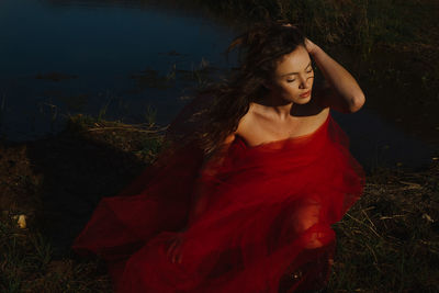 Young female model posing at lakeshore