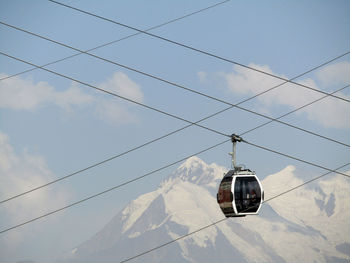 Low angle view of overhead cable car against sky