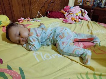 Cute baby lying on bed at home