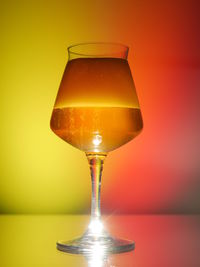 Close-up of wineglass against yellow background