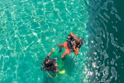 High angle view of friends scuba diving in sea