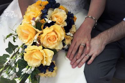 Midsection of couple holding bouquet