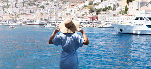 Rear view of woman standing on boat in sea